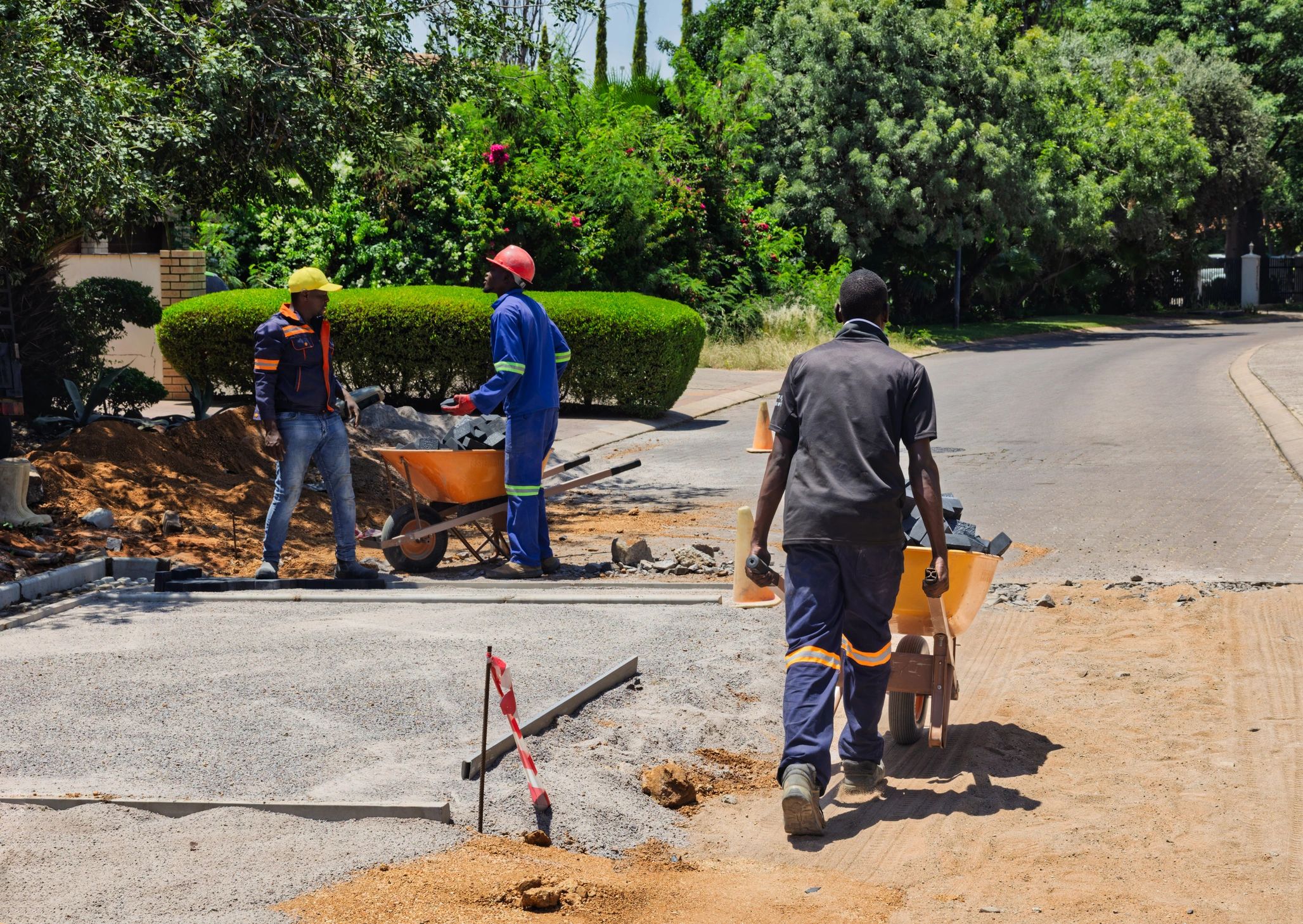Construction crew moving materials with wheelbarrows on a residential project